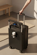 Black suitcase with a cup holder and digital display on a tiled floor.