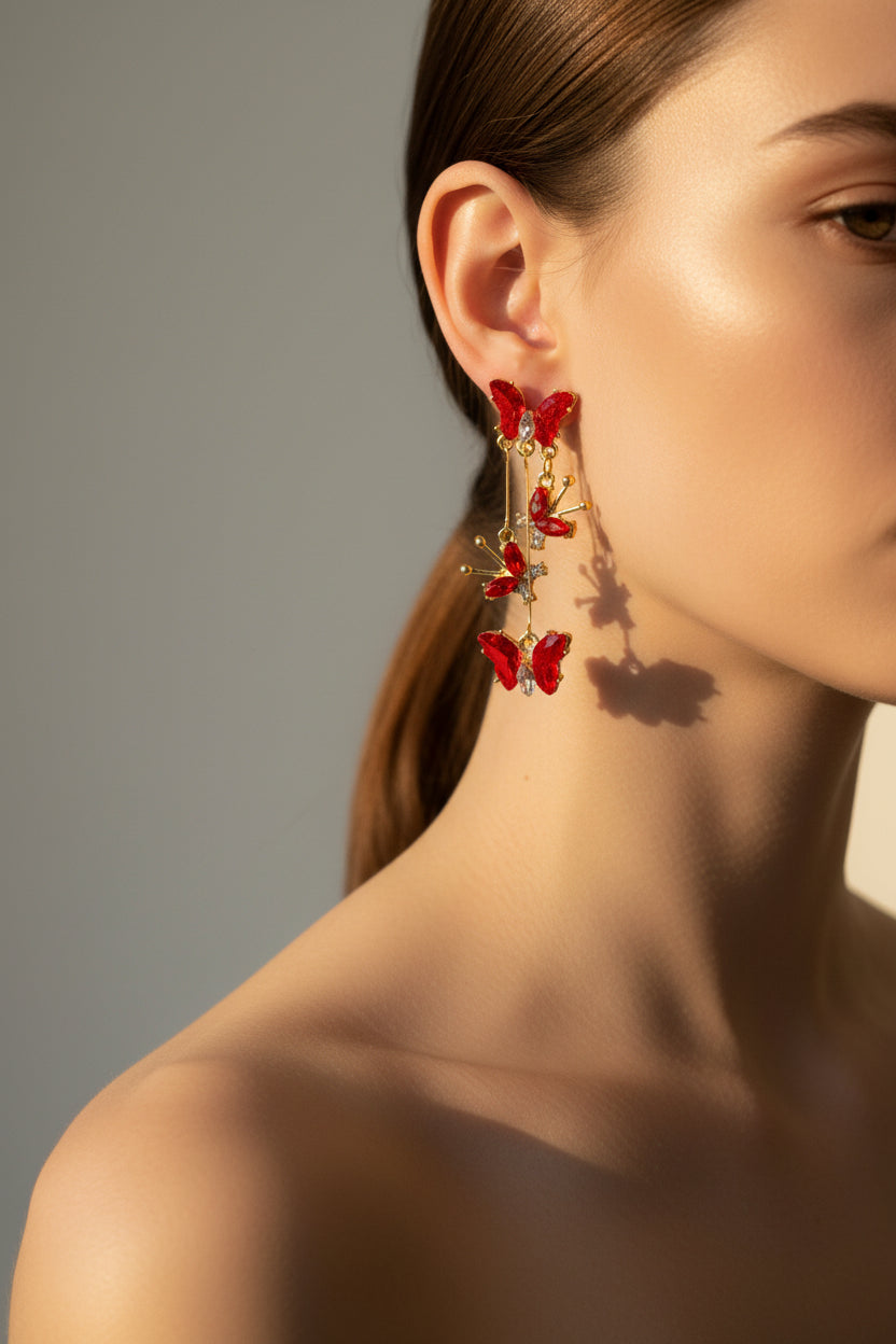 Red butterfly earrings on a wooden stand with a neutral background
